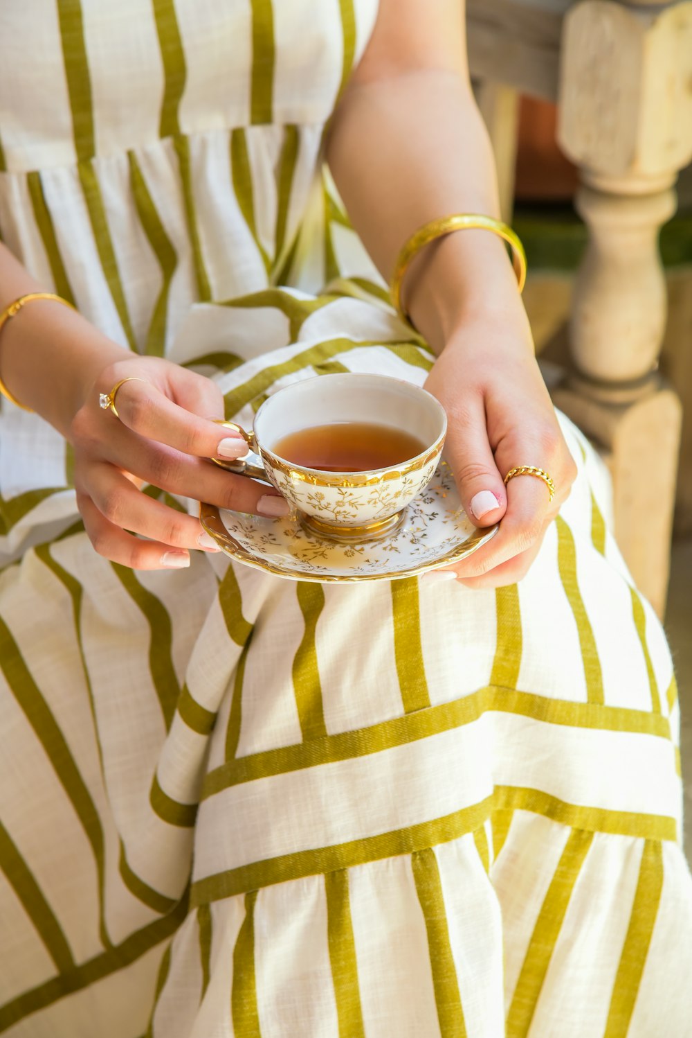 Leila Nahasar, founder, holding a decorative teacup of Persian chai on her lap