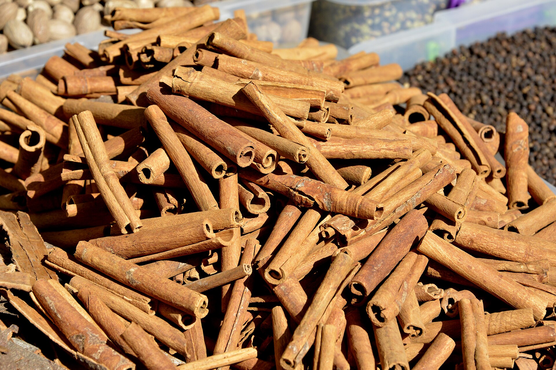 A spice stall in the Grand Bazaar piled with cinnamon sticks, dried fruits and mounds of saffron and sumac, warmly lit